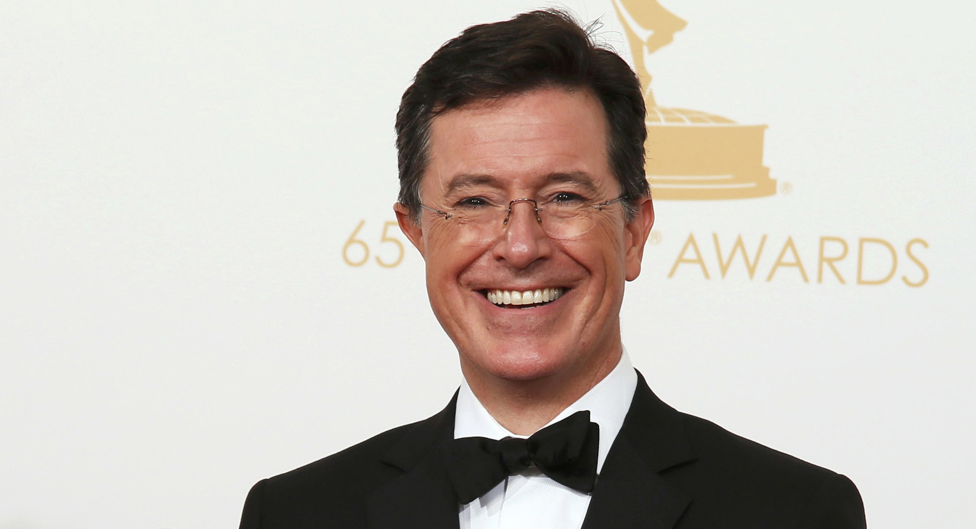 Colbert poses with awards at 65th Emmy Awards in Los Angeles in 2013