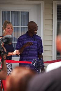 Dolphus Johnson cuts the ribbon on his new home at 112 Rose Avenue in Syracuse July 22. (Sun photo | Chuck Wainwright)