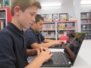 Sixth-graders Luke Boule, left, and Daniel Stark work on their Chromebooks Sept. 21 at Holy Cross School. -SUN PHOTO | TOM MAGUIRE
