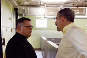 Bishop-elect Lucia speaks with Mike Melara, executive director of Catholic Charities for the Diocese of Syracuse, inside Catholic Charities’ Men’s Shelter