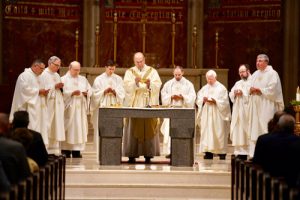 Concelebrates Mass with Bishop Robert J. Cunningham and several priests of the diocese