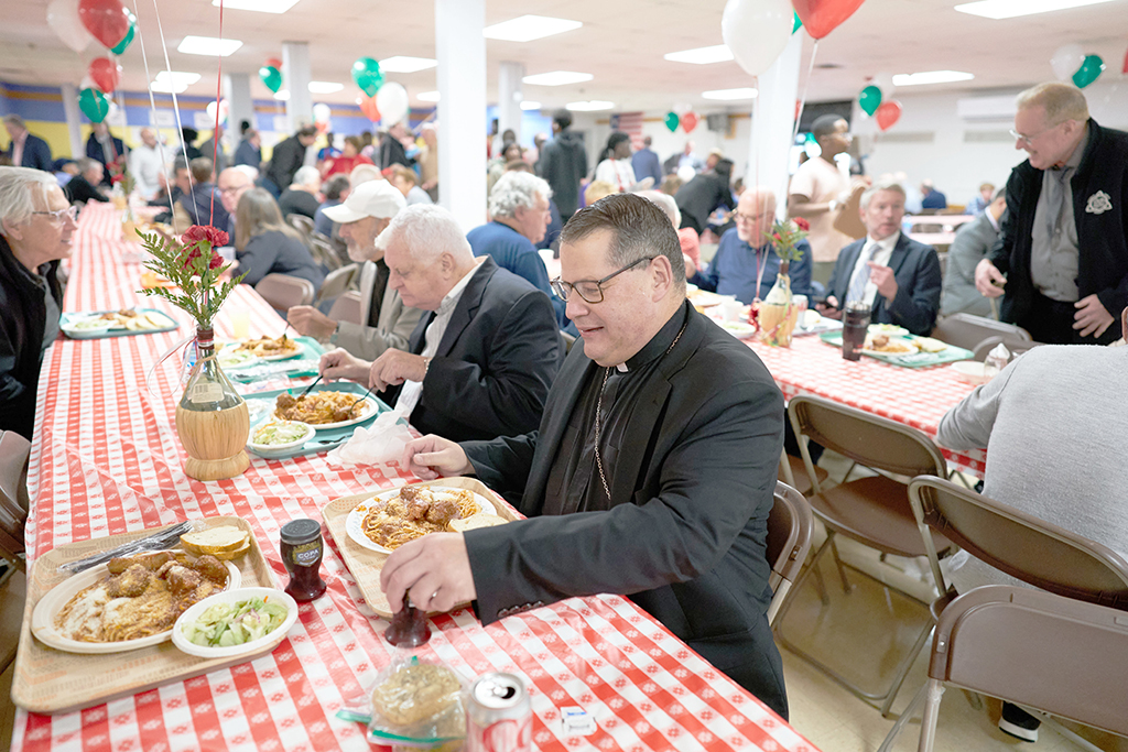 Bishop smiles at table