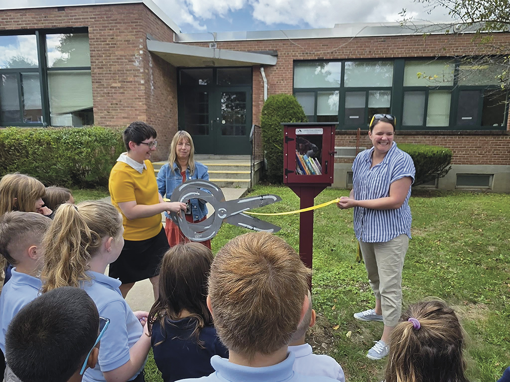 Ms. Browne Librarian Cutting the Ribbon with Mrs. Ballin