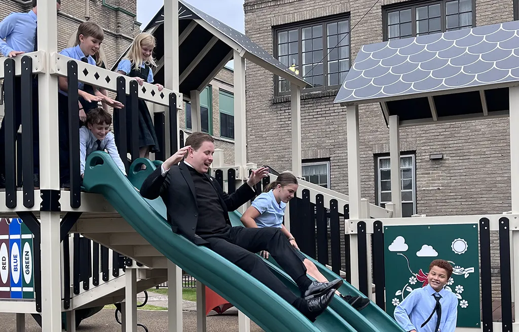 Fr. Ryan + students on slide