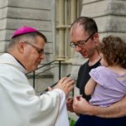 Bishop-elect Lucia blesses Bennett McLoughlin and daughter Emeline following Mass at the Cathedral of the Immaculate Conception